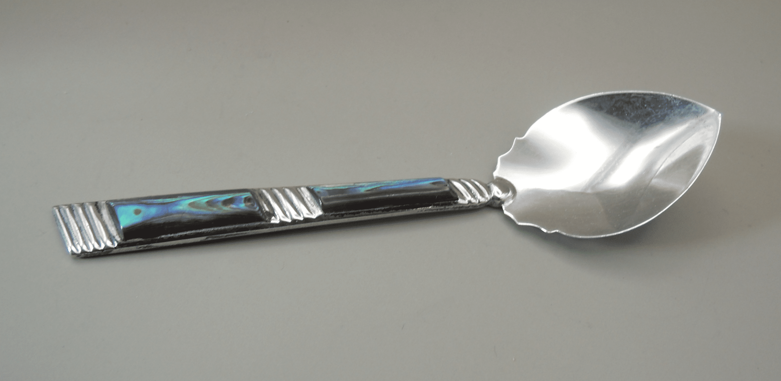 A Sterling Silver spoon with abalone shell decoration